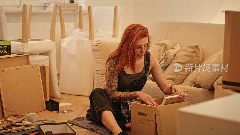 单身女人在新公寓里打开纸箱。