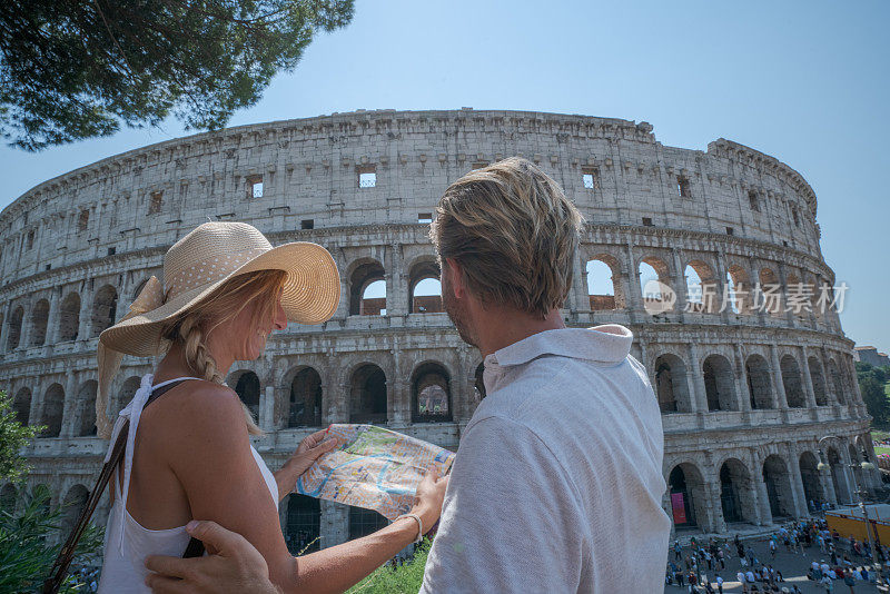 一对年轻夫妇在罗马斗兽场看旅游城市地图问路