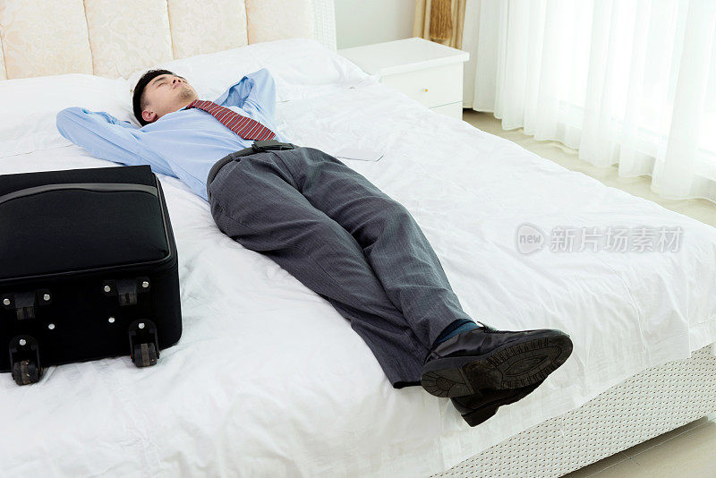 商人躺在床上拿着行李