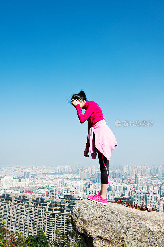 女人在山巅岩石的边缘往下看