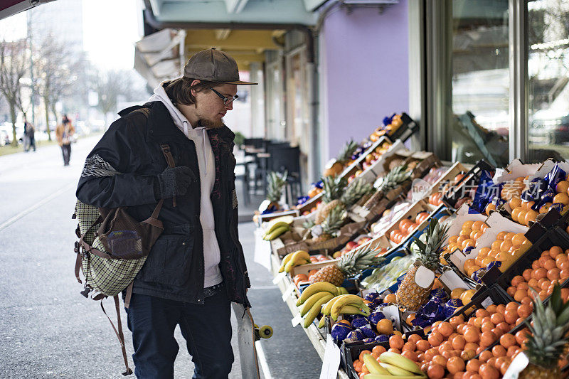 成年男性在农贸市场挑选水果
