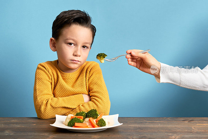 孩子对不得不吃蔬菜很不高兴。