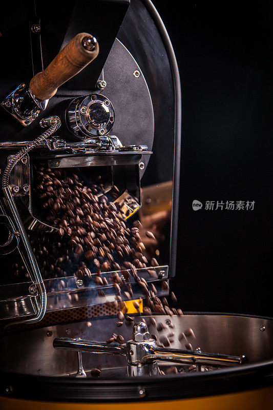 咖啡豆从大型烘培机上掉下来