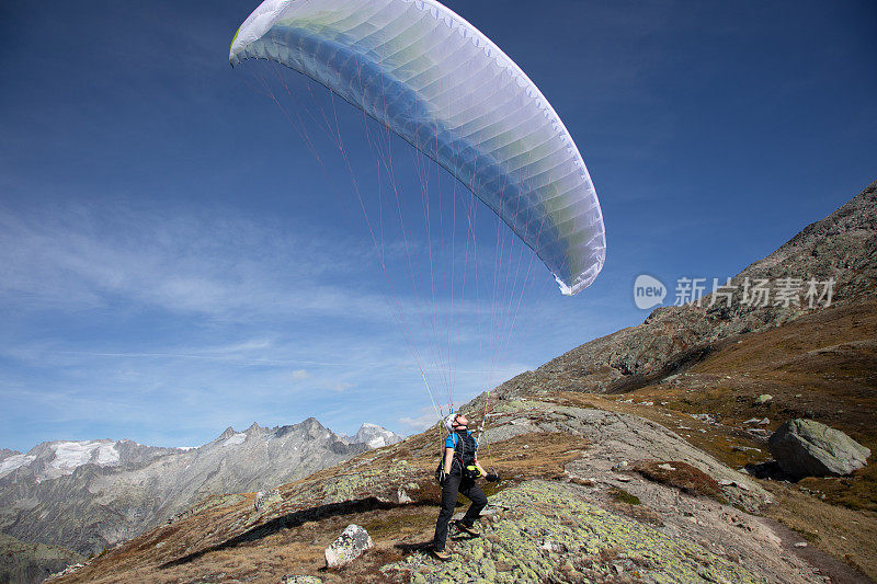 年轻的滑翔伞飞行员用他的滑翔伞在瑞士阿尔卑斯山与风玩，所谓的地面处理