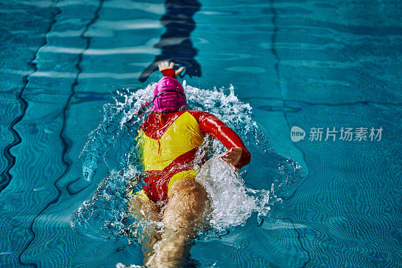 女子运动员在自由泳中快速游泳。水花四溅向不同的方向。