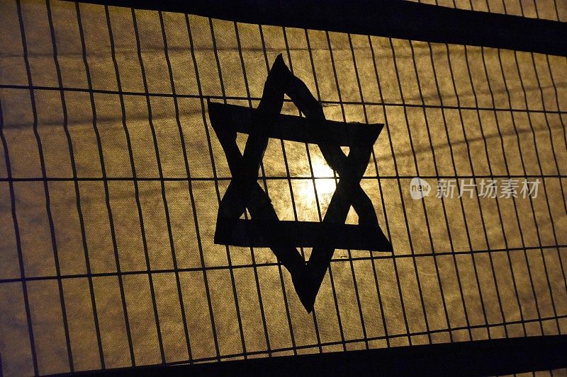 一面以色列国旗和大卫之星在铁栅栏旁