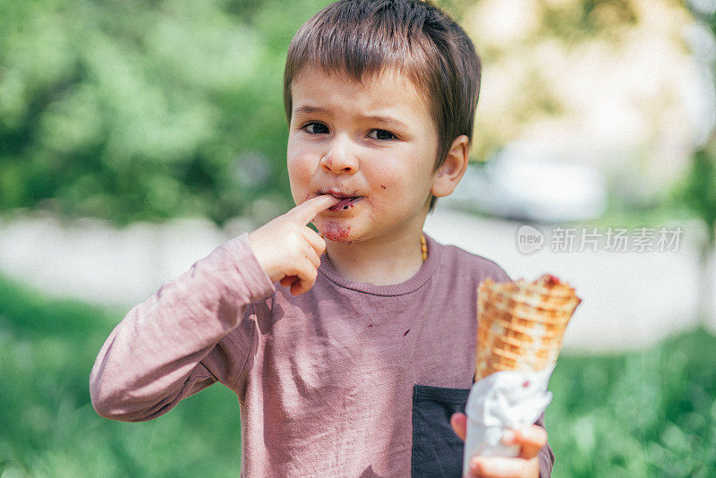 一个可爱的男孩在吃华夫饼冰淇淋蛋卷