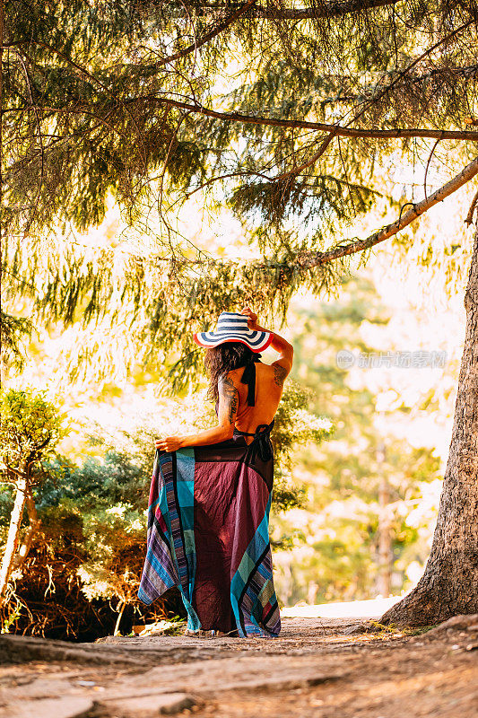 穿衣服的女人在树林中指着她的背影