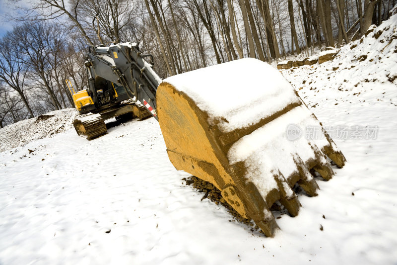 大型黄色履带挖掘机停在雪地里