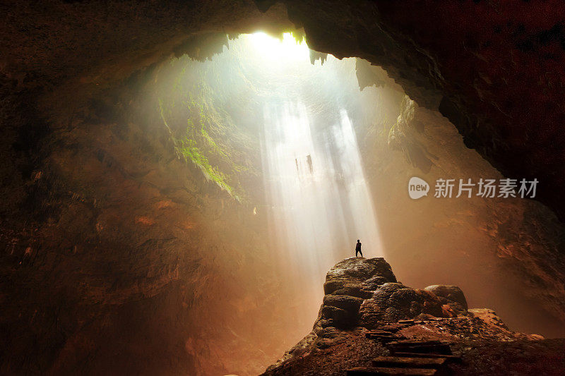 男子站在岩石地下洞穴光日惹印度尼西亚