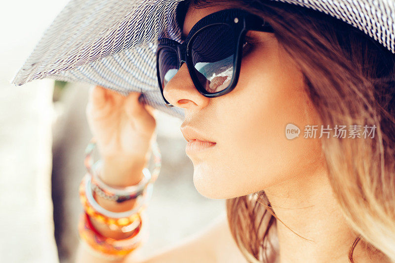 年轻的夏日女孩戴着帽子和太阳镜