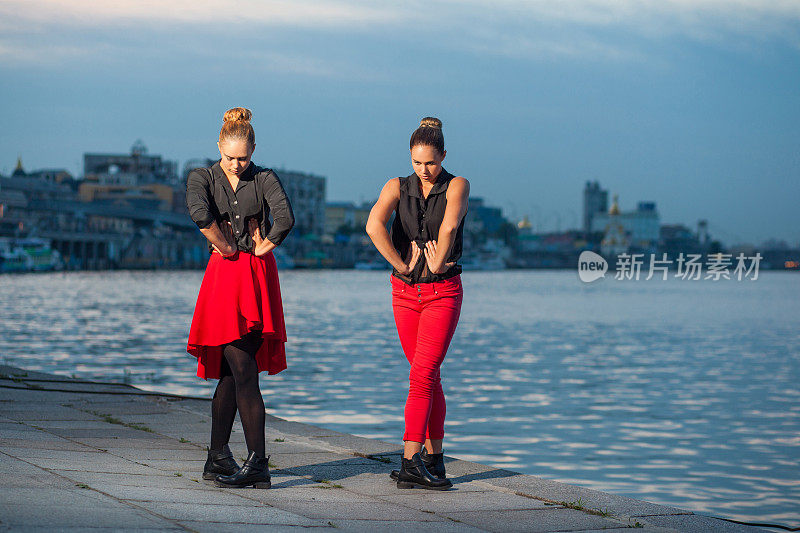 两个年轻漂亮的双胞胎姐妹在河边跳舞