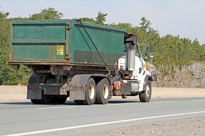 高速公路上的卡车在运送一个工业垃圾桶