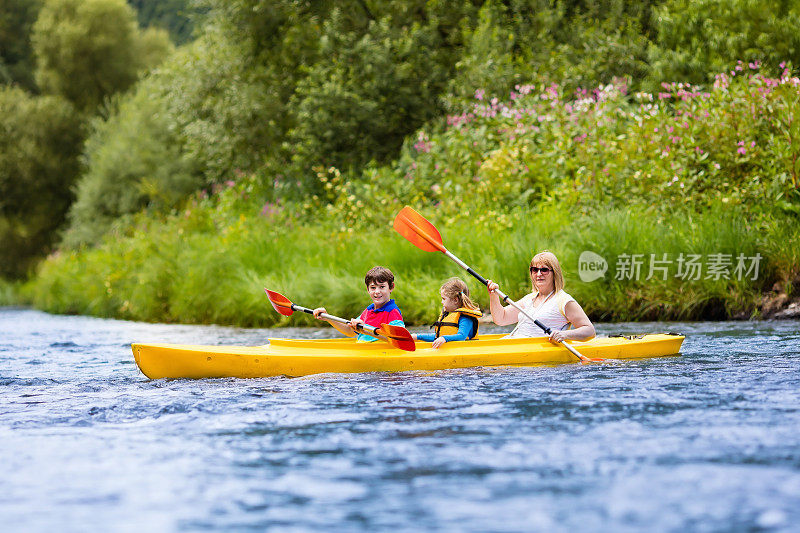 幸福的家庭在河上享受皮划艇
