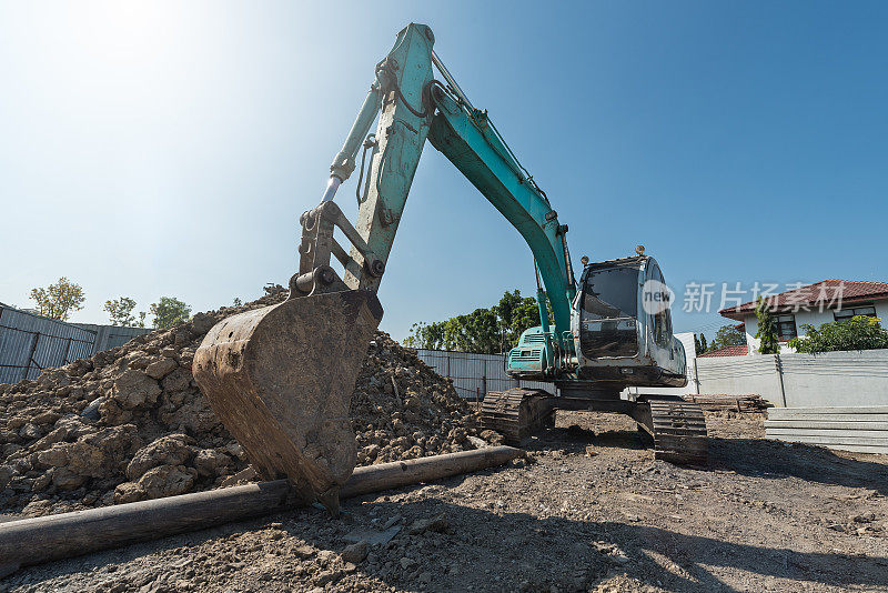 挖掘机在施工现场，挖掘机在砂砾堆上用铲子铲