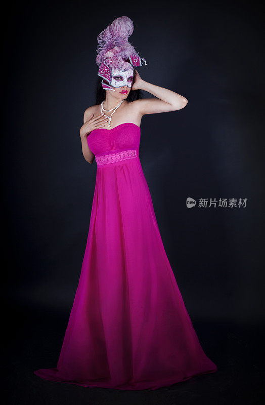 穿着粉色裙子，戴着威尼斯面具的性感女人