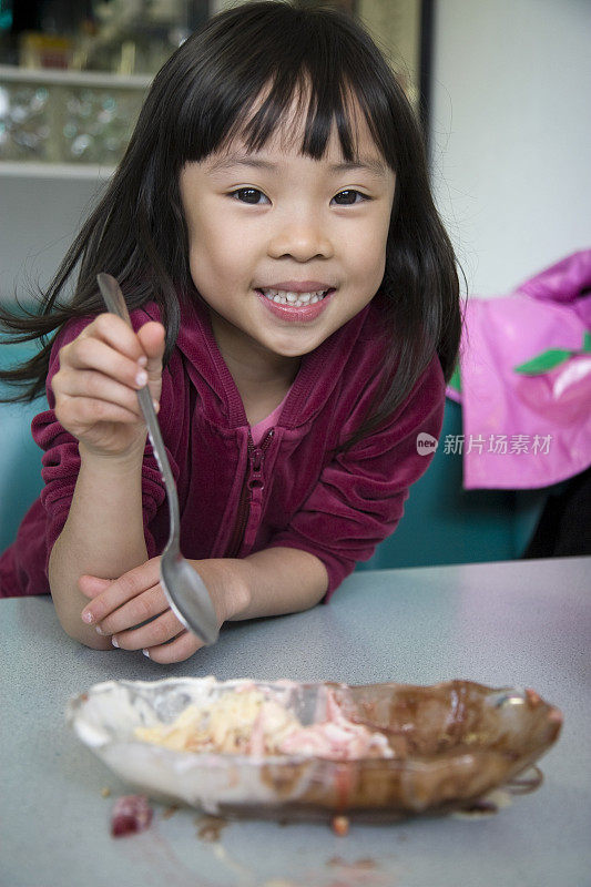 可爱的亚洲小女孩在冰淇淋店吃圣代