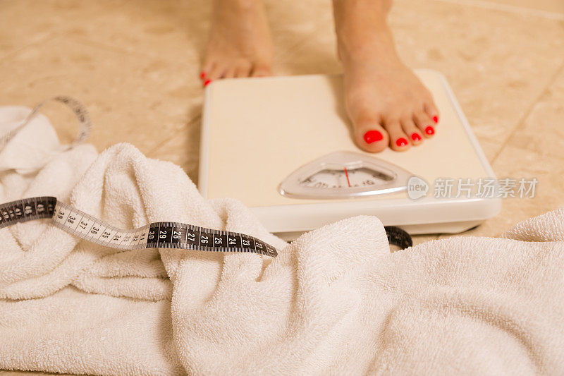 健康生活方式:体重意识女性的秤。卷尺、毛巾。