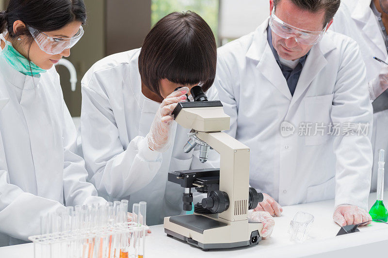 化学家正在通过显微镜观察