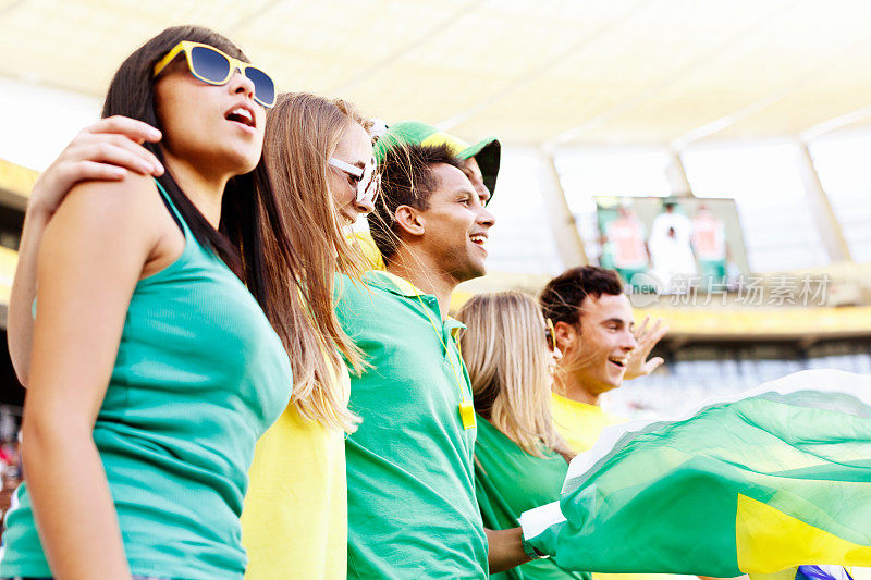 快乐的巴西球迷欢呼并挥舞旗帜