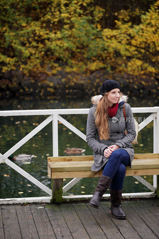 女人坐在秋天的公园里