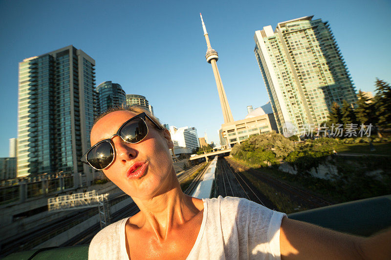 年轻女子在多伦多旅行，与城市风景自拍