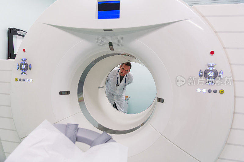 来自肿瘤研究所的场景…年轻医生站在PET扫描设备后面