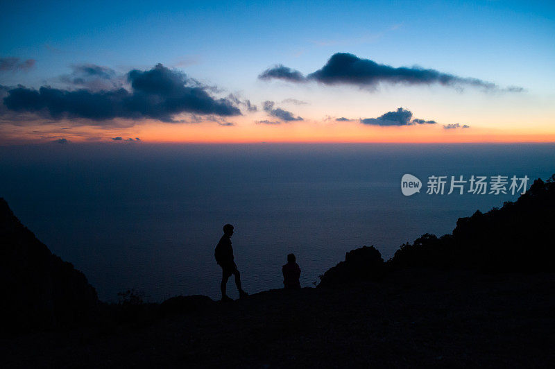 夕阳下的海面上有两个剪影