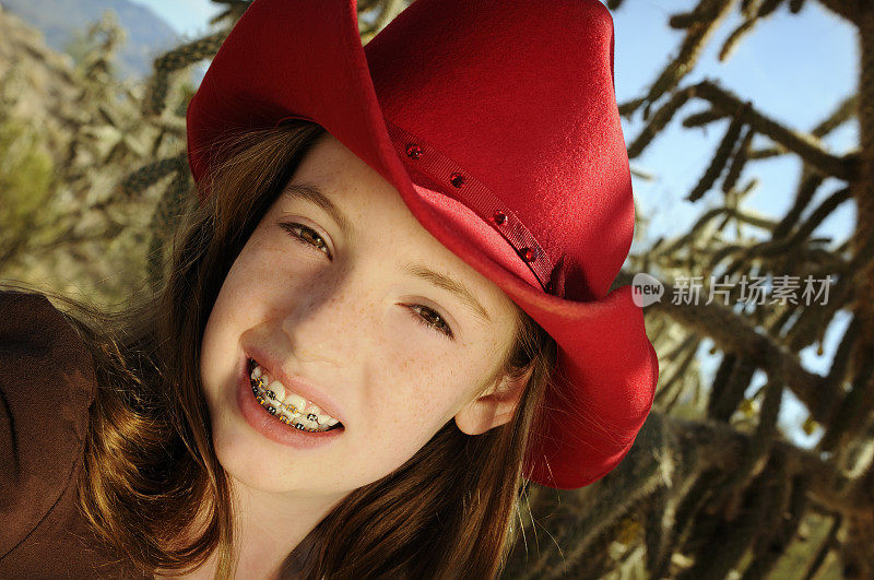 年轻的少年在牙套和明亮的红帽子