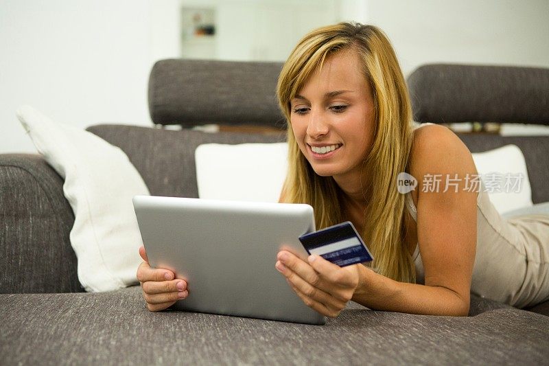 妇女在家使用数字平板电脑在线购物