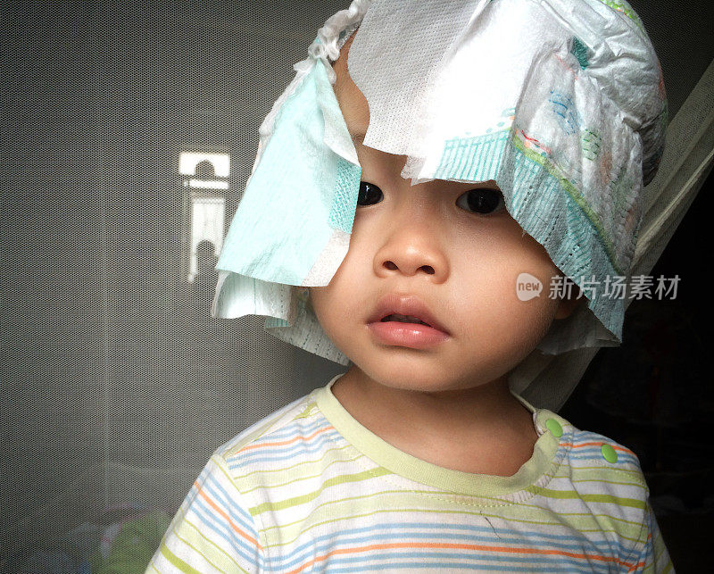 亚洲可爱的孩子穿尿布当帽子