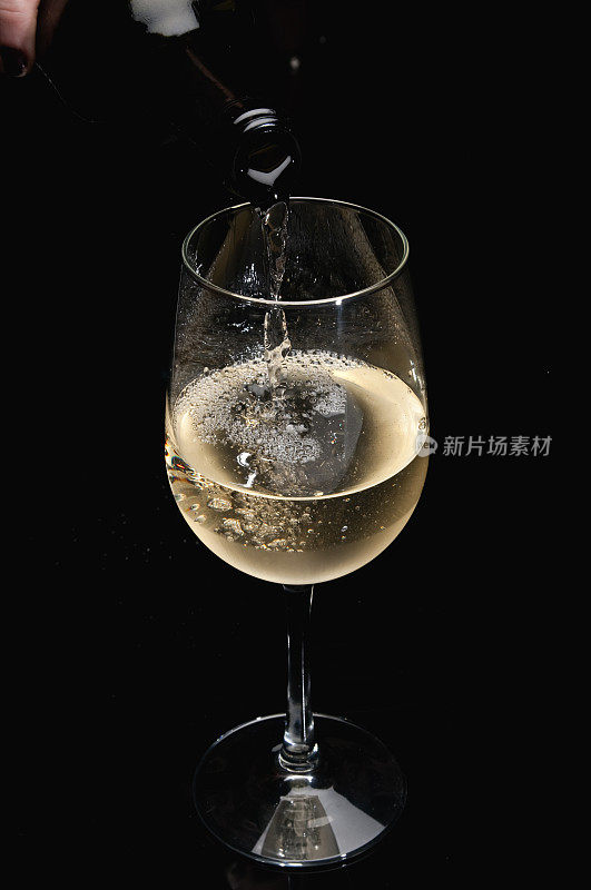 将白葡萄酒倒入玻璃杯中