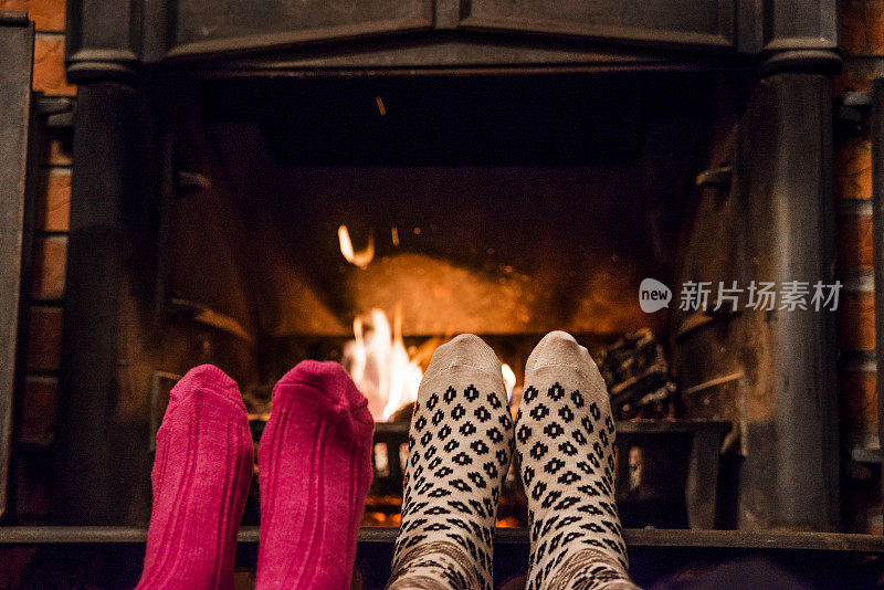 在壁炉前，一对穿着袜子的情侣的浪漫腿