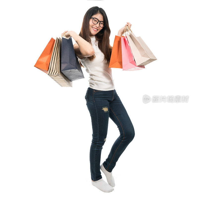 美丽的亚洲女孩双手拿着购物袋，孤立在白色背景，生活方式或购物狂概念