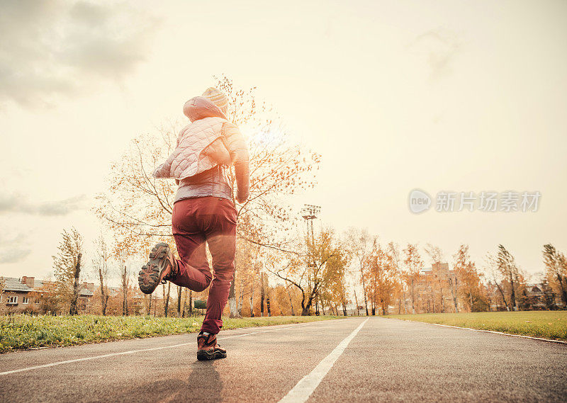 在体育场跑道上跑步的女人