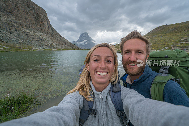 一对年轻夫妇在瑞士徒步旅行的自拍照片，马特洪峰