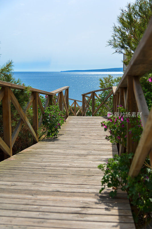 带楼梯的通往海滩的木制人行道或跳板