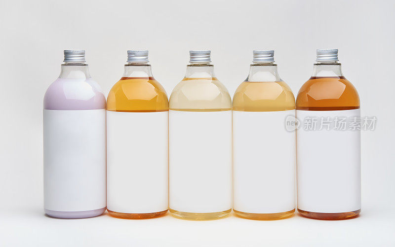一套不同的美容、卫生和健康的瓶子，在白色的背景上反光，它们可以洗发、护发素和其他护发产品