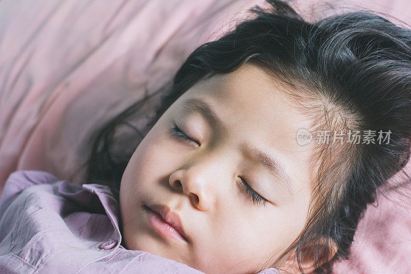 亚洲人喜欢睡在床上玩累了和健康的孩子休息。