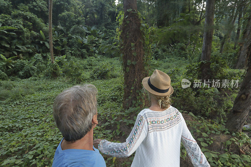 一对夫妇凝视着丛林，一个女人向前走去