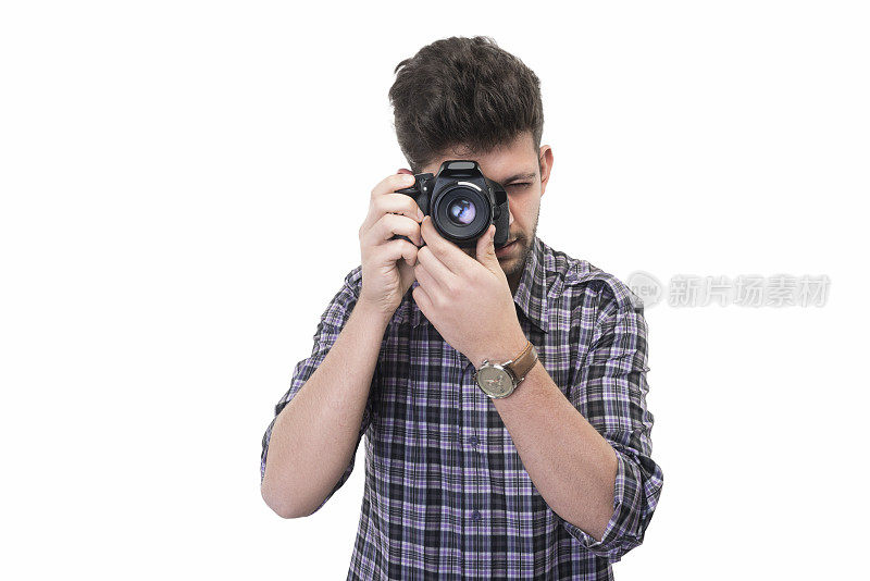 年轻摄影师的肖像透过相机的取景器和拍摄的照片在白色的背景