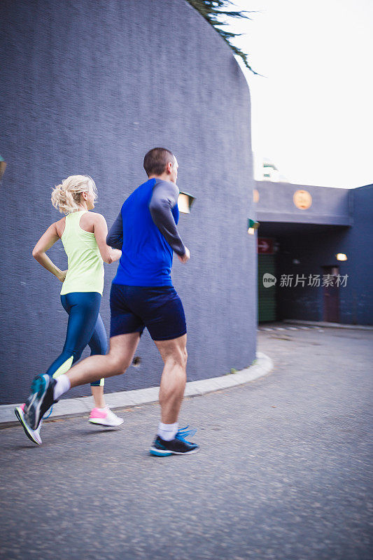 一对运动员夫妇在城市的街道上晨跑