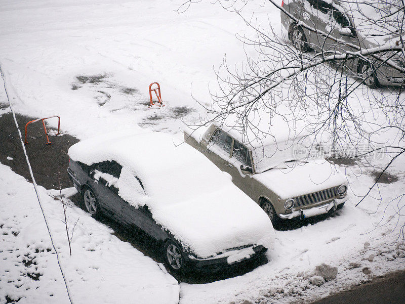 院子里的旧汽车被雪覆盖着。