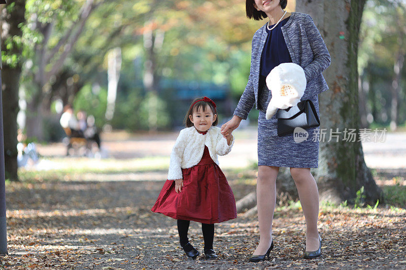 日本母亲与她的女儿走在志一去桑庆祝