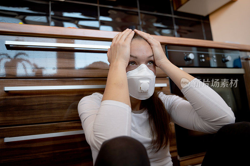 绝望的年轻女子在冠状病毒隔离期间戴着口罩在家拍照
