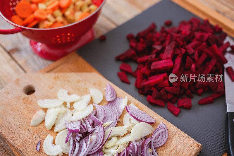 切菜板上放生甜菜根、胡萝卜、土豆和洋葱