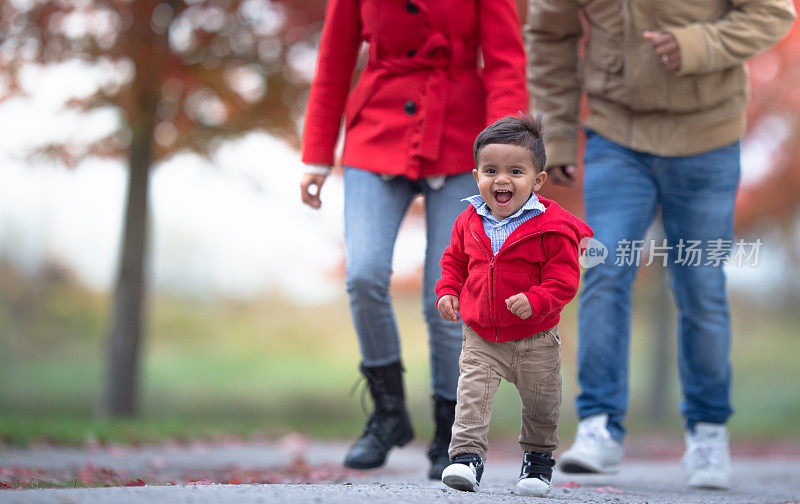 一家人在秋天和蹒跚学步的孩子一起散步
