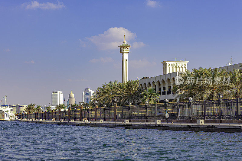 阿拉伯联合酋长国迪拜——图片右侧是迪拜酋长办公室的椰枣树和栅栏;紧邻统治者办公室的清真寺的单一尖塔也可以看到。副本的空间。