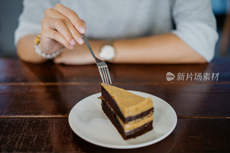 亚洲女人在咖啡厅吃一块蛋糕