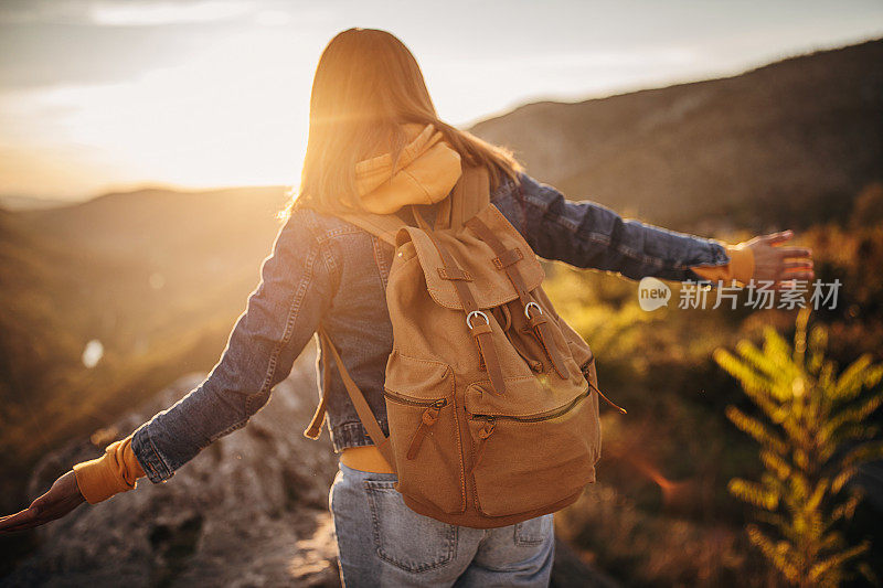 一个女人在山顶行走时保持着平衡